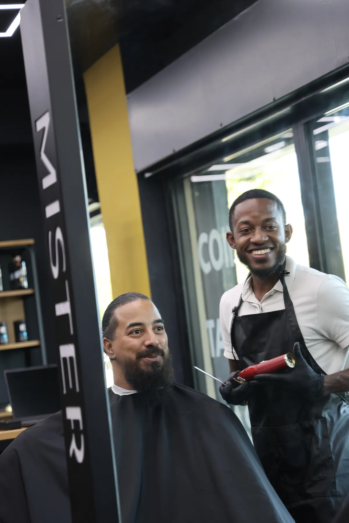 Client et coiffeur souriants dans le miroir Mister Hype, coupe terminée