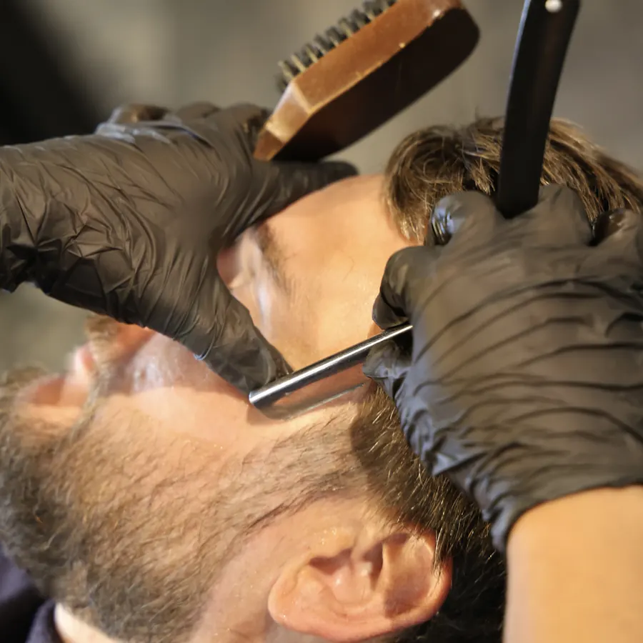Rasoir et brosse sur la barbe, geste précis