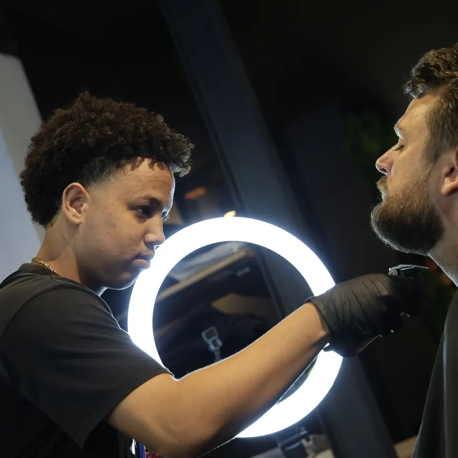 Coiffeur et client de part et d'autre du ring light