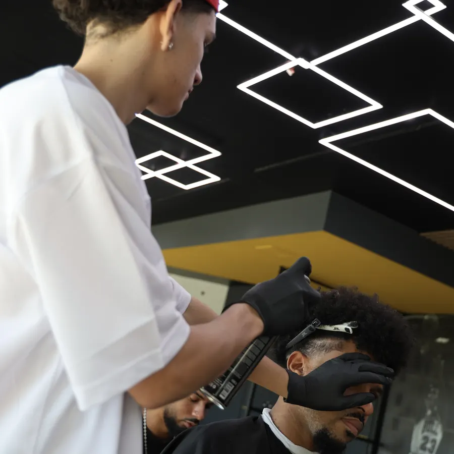 Duo coiffeur-client sous le plafond de néons